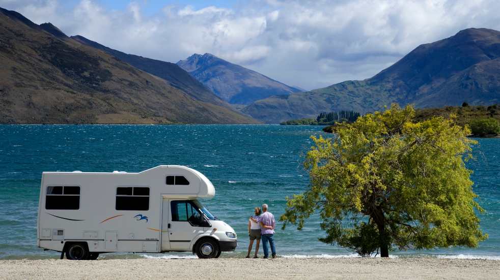 Couple with motorhome by lake